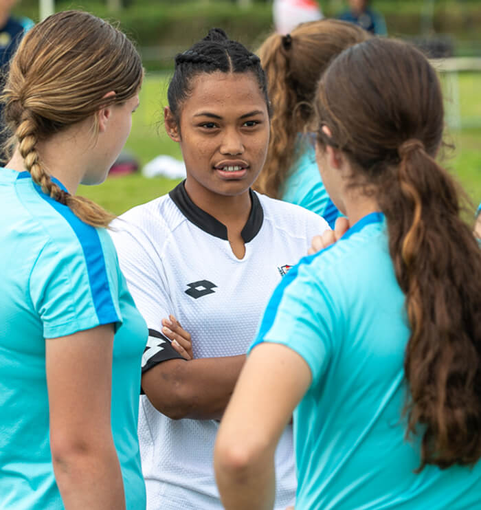 Pacific female athlete talking to Australian female athletes