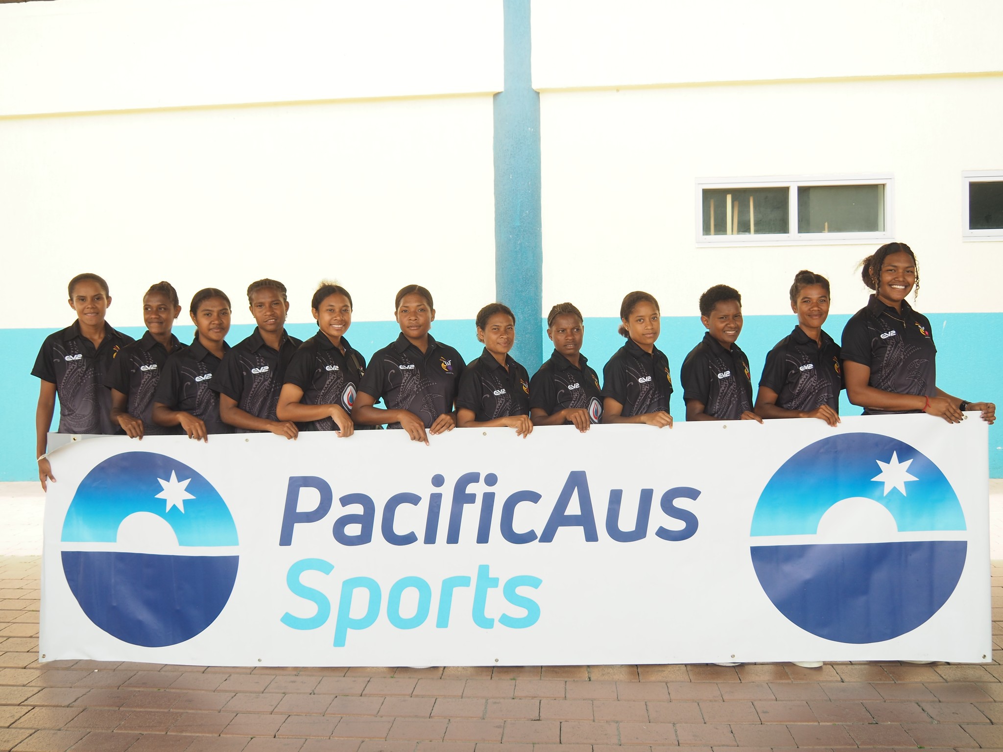 Team photo behind PacificAus Sports banner
