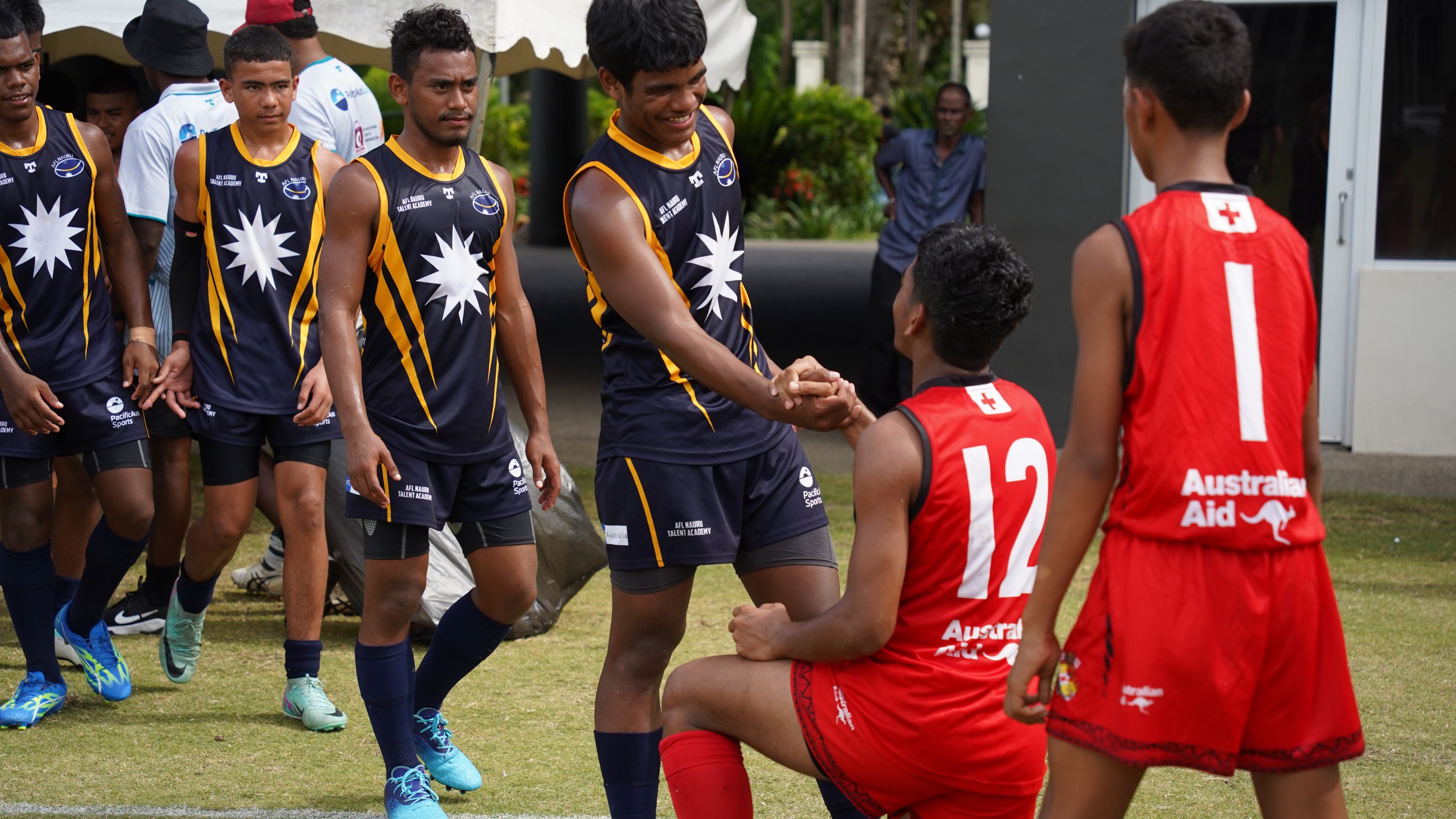 Aussie rules players hand-in-hand