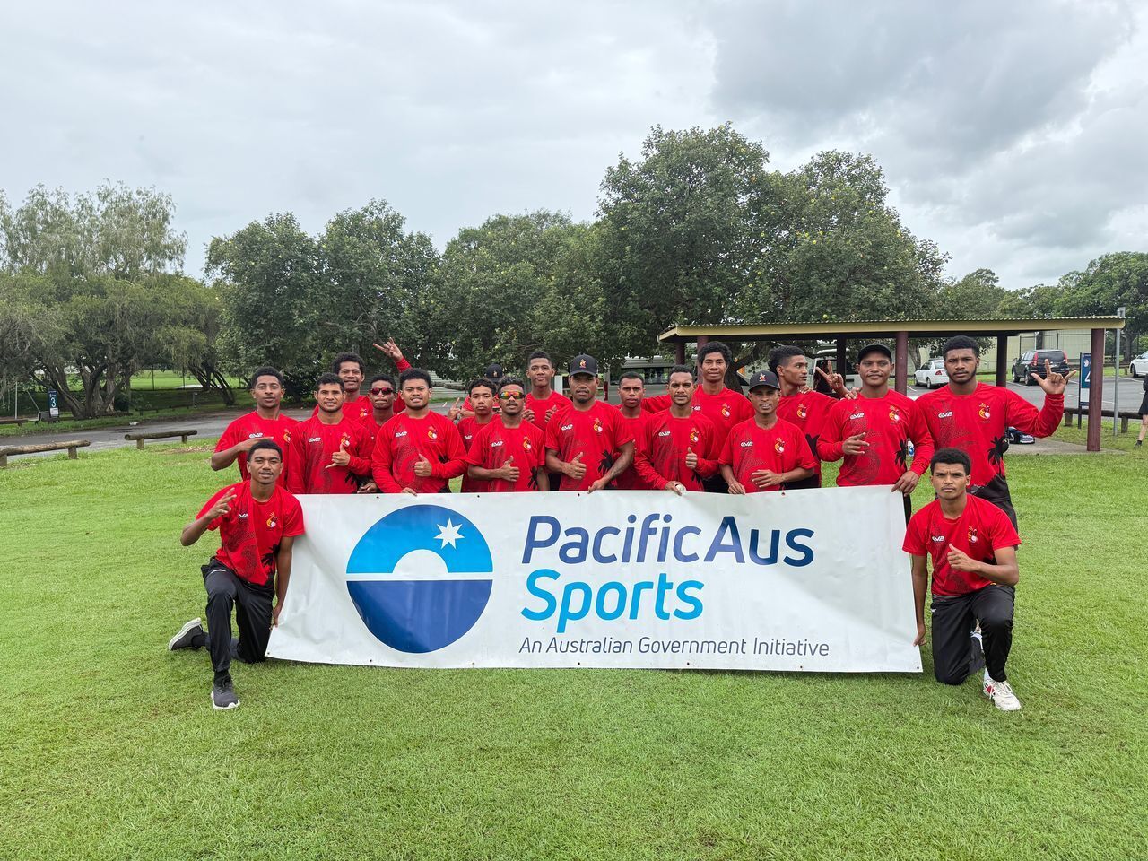 The PNG Garamuts cricket team with a PacificAus Sports banner